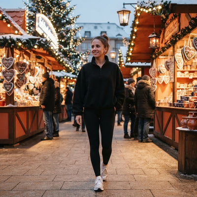Woman wearing a soft fleece pullover with a half-zip at a festive Christmas market, emphasizing cozy warmth.